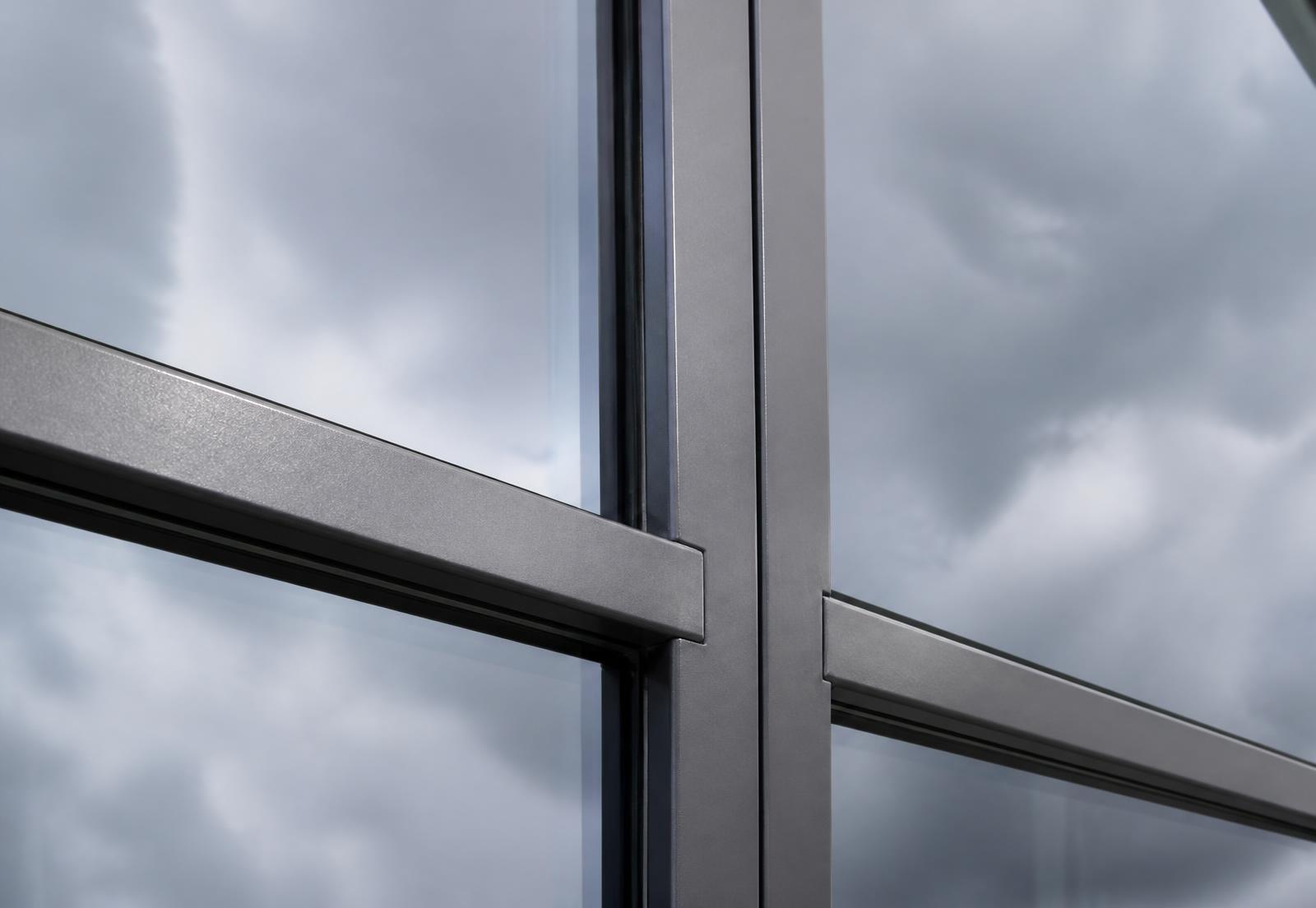 Detail of a commercial curtain walling junction showing an aluminium mullion, transom and structural silicone joint